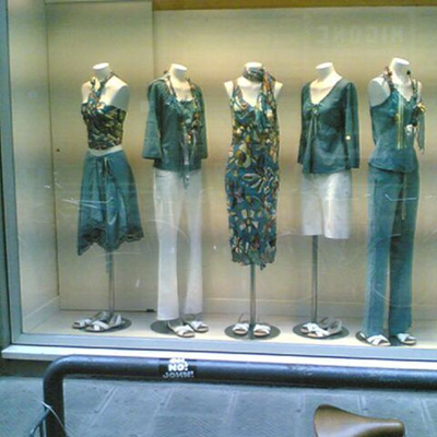 Window display with mannequins wearing similar outfits