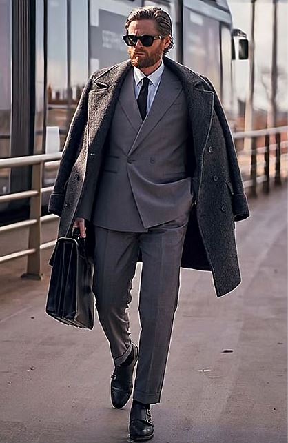 Man in a gray Chester coat draped over a suit
